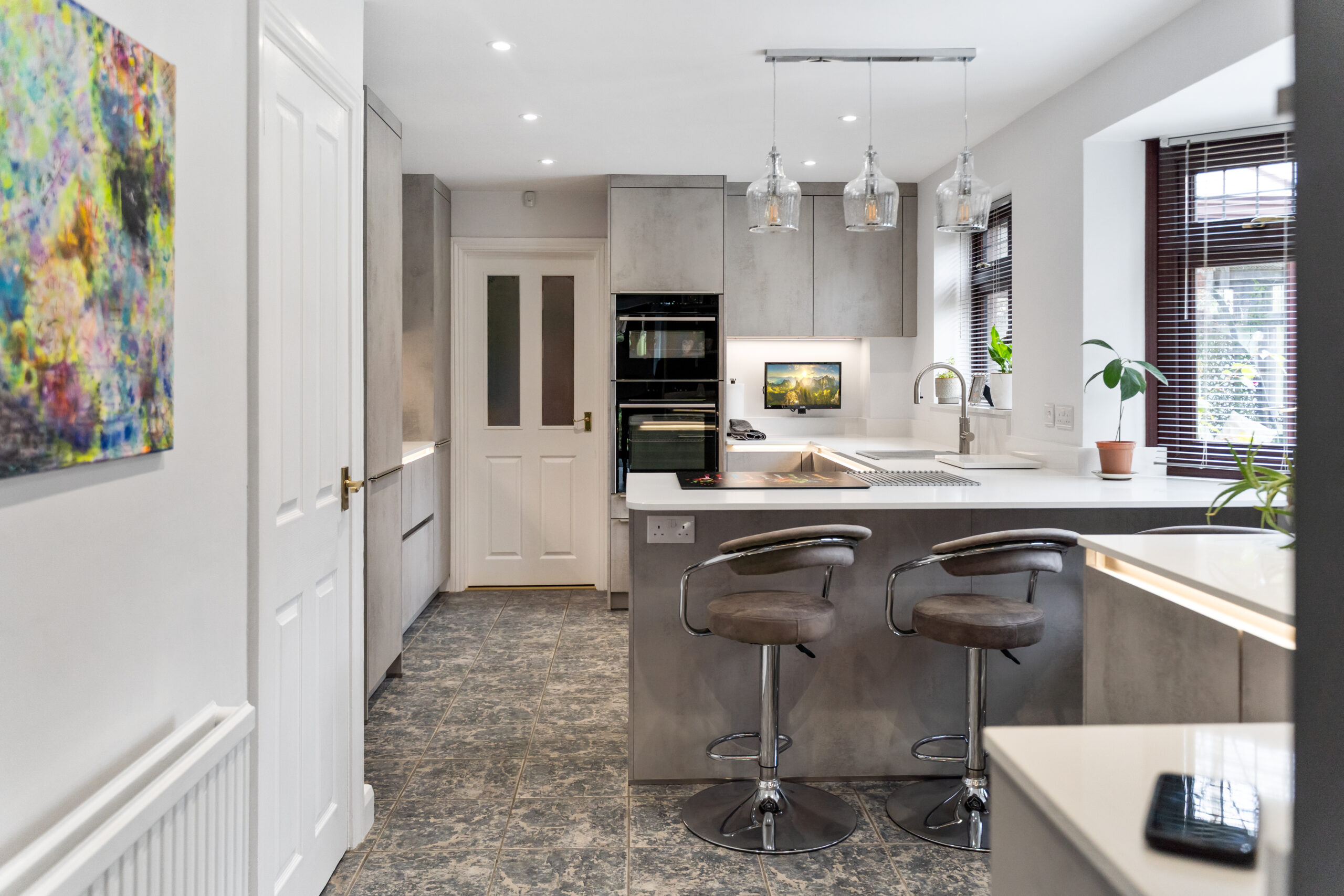 Cashmere handleless kitchen with oak wall units, peninsula and grey bar stools