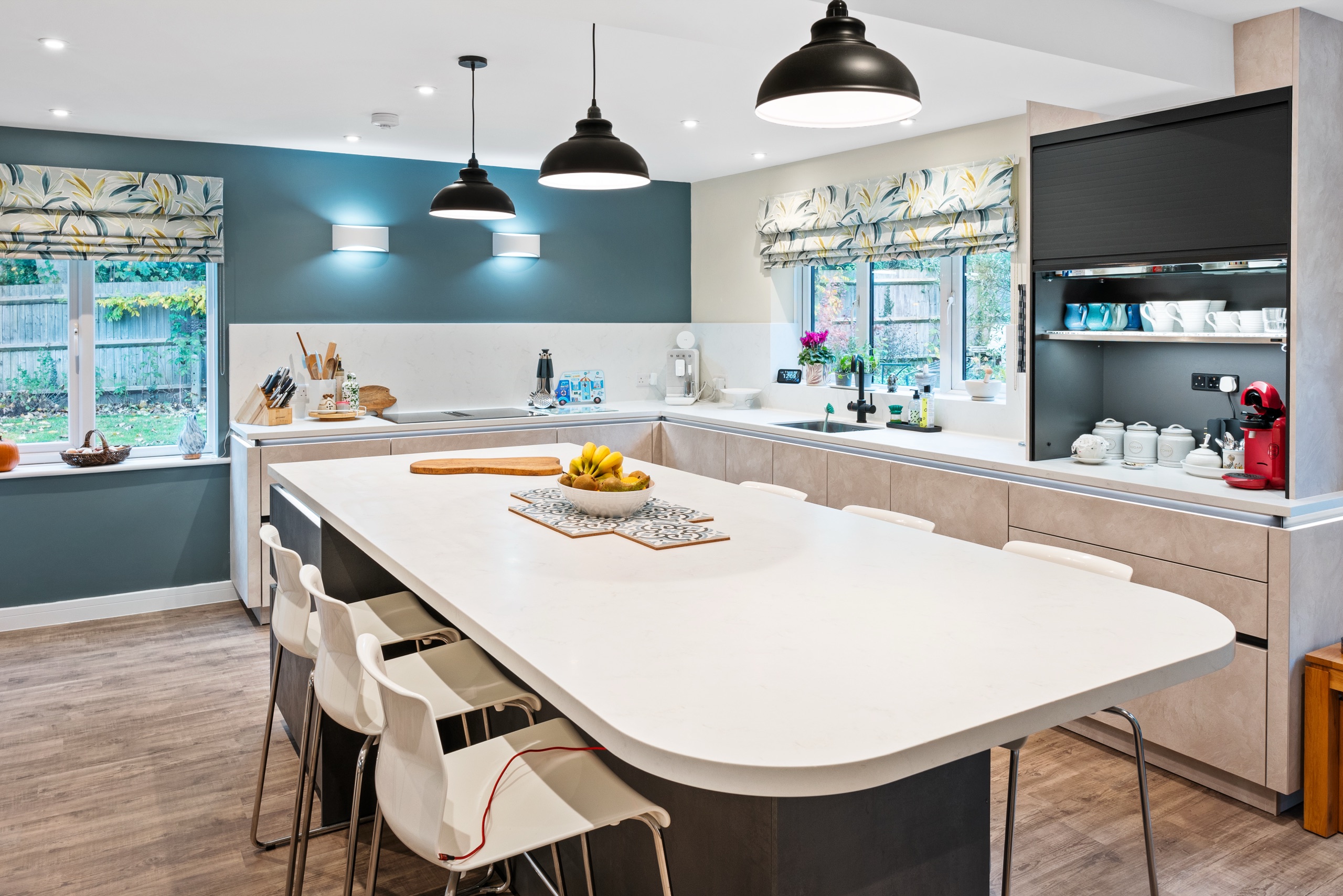 Elba kitchen in Slate Sand Effect with a dark island, white worktop and teal feature wall