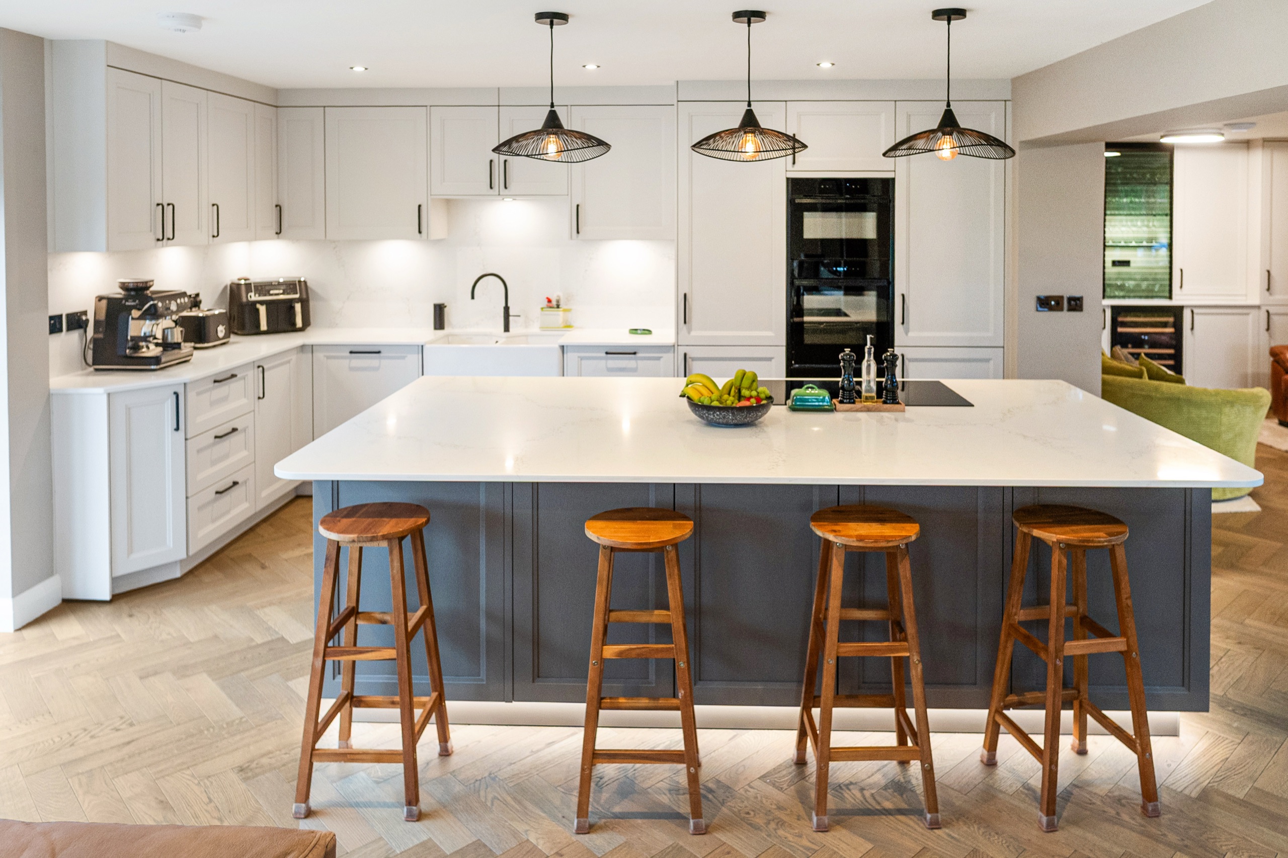 Finca kitchen in Seashell White and Agate Grey with a grey island and herringbone flooring